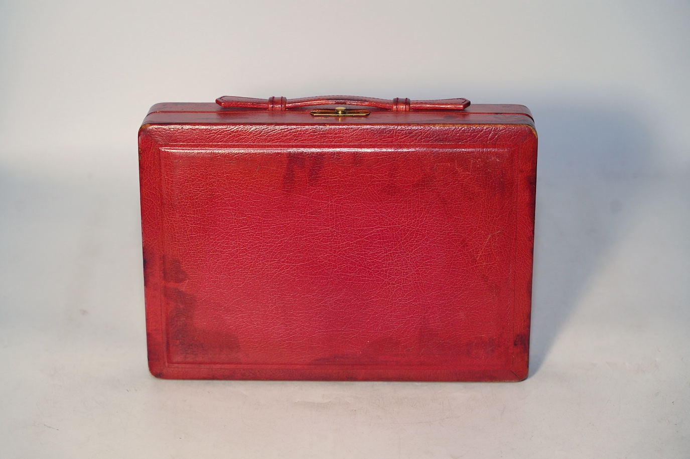 A Geoffrey Parker red leather backgammon set and a black leatherette wrist watch case